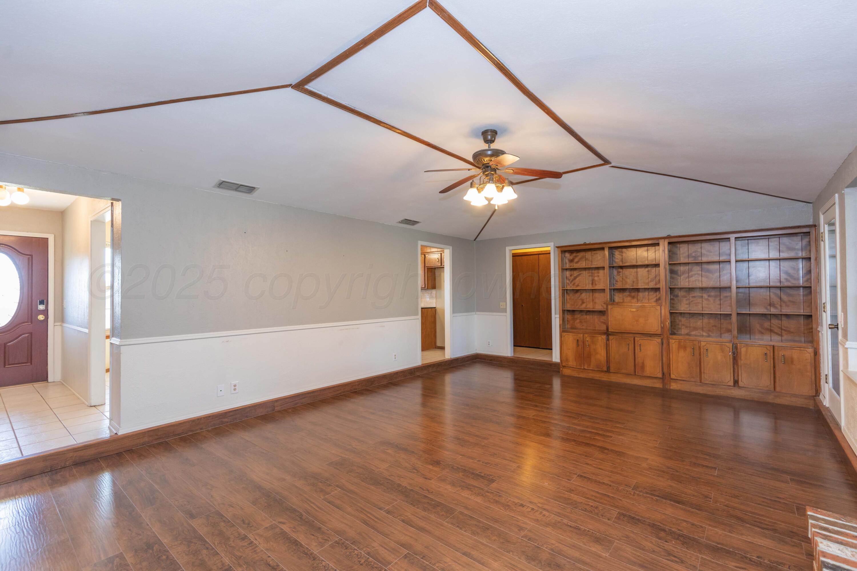 134 Eddie Street Canadian, TX 79014 - Photo 8 of 45 an empty room with wooden floor and windows