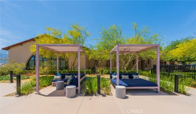 a view of a patio with couches table and chairs under an umbrella