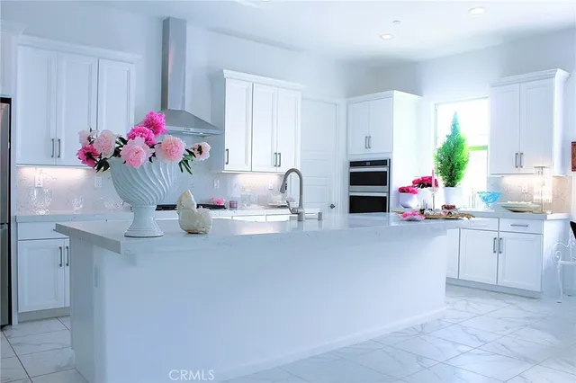a kitchen with white cabinets and appliances