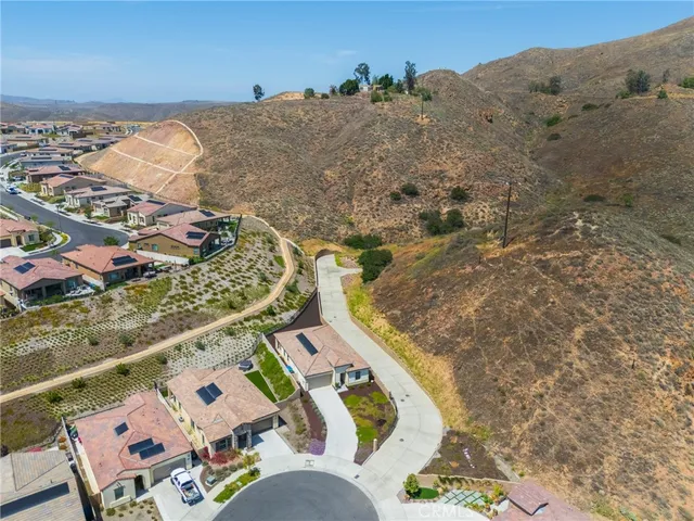 an aerial view of a house with a mountain