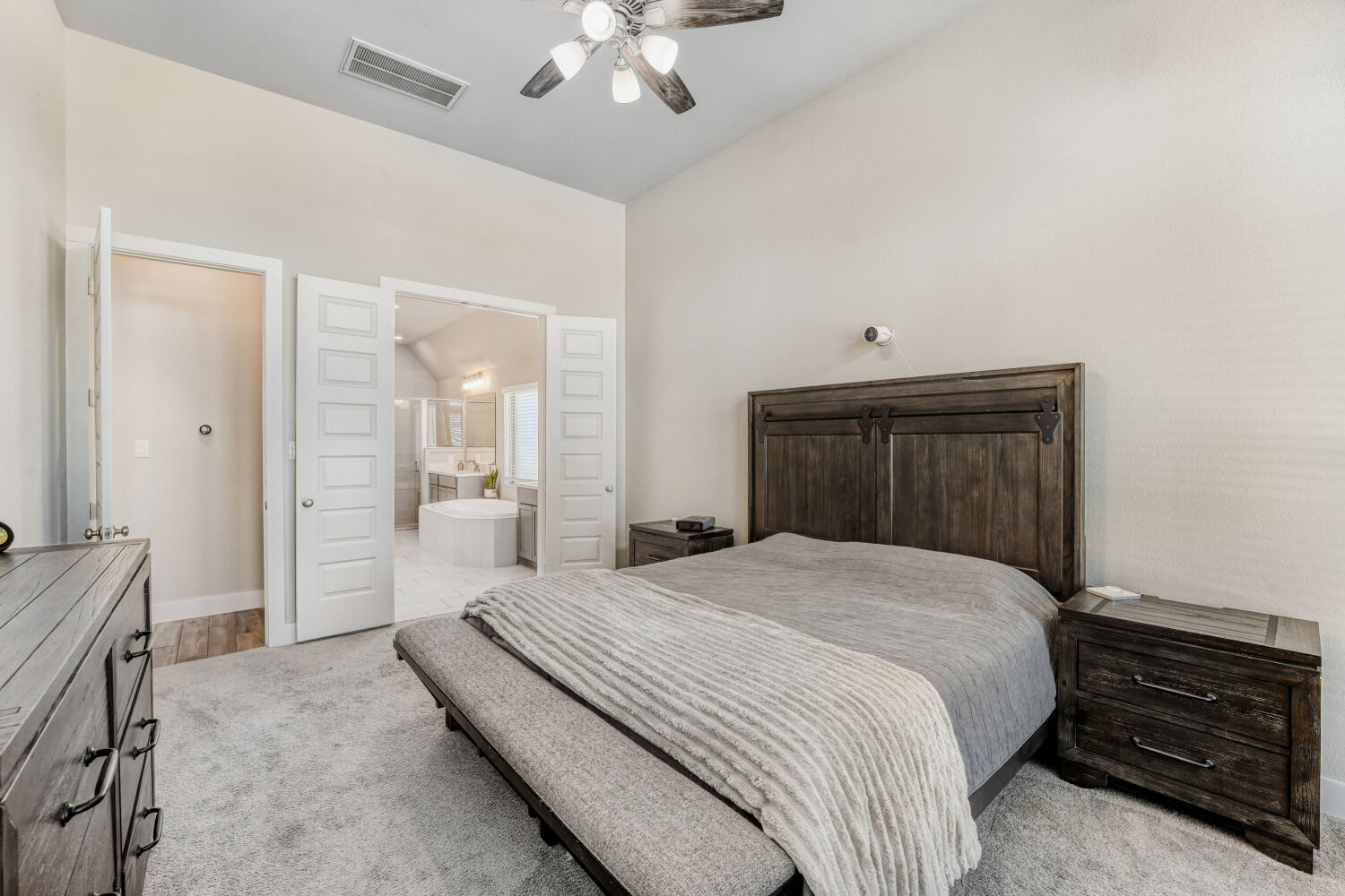 505 Trout River Road Kyle, TX 78640 - Photo 13 of 29 Bedroom with light colored carpet, ceiling fan, and ensuite bath