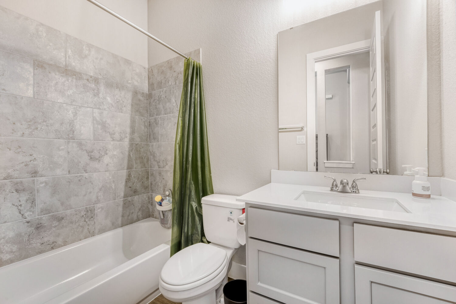 505 Trout River Road Kyle, TX 78640 - Photo 17 of 29 Full bathroom featuring a textured wall, vanity, and shower / bath combination with curtain