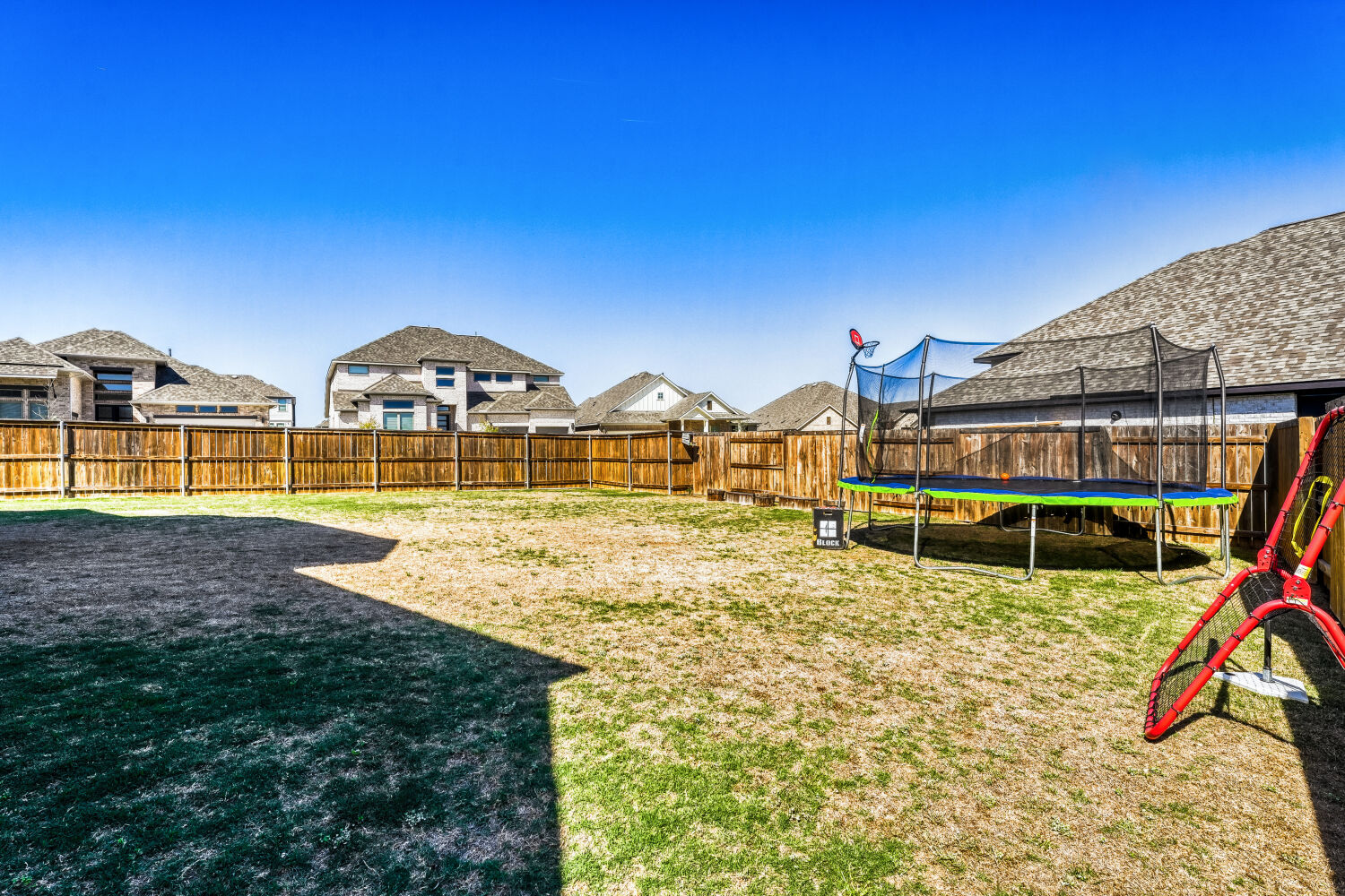 505 Trout River Road Kyle, TX 78640 - Photo 27 of 29 Fenced backyard with a residential view and a trampoline