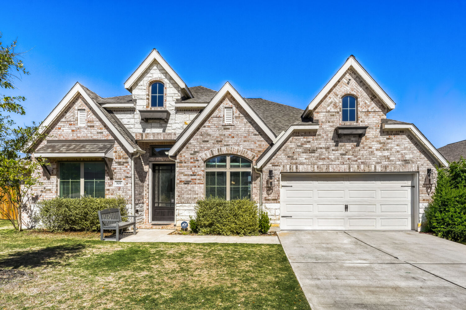 505 Trout River Road Kyle, TX 78640 - Photo 28 of 29 French country inspired facade with brick siding, driveway, a garage, and a front yard