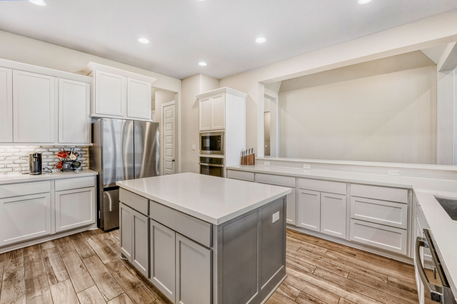 505 Trout River Road Kyle, TX 78640 - Photo 7 of 29 Kitchen featuring stainless steel appliances, a kitchen island, light wood-style flooring, dual tone cabinets, and recessed lighting