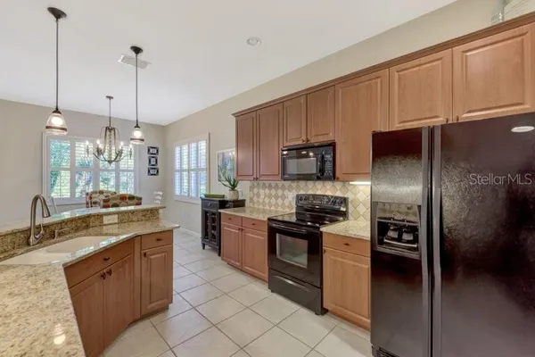 a kitchen with stainless steel appliances granite countertop a stove a sink and a refrigerator