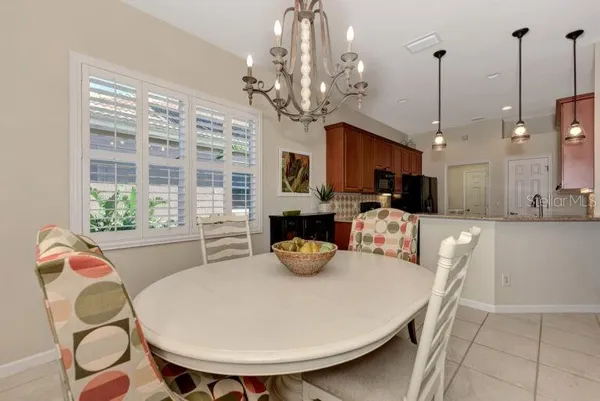 a kitchen with sink refrigerator dining table and chairs