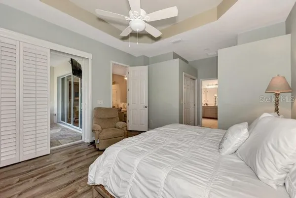 a bedroom with a large bed and ceiling fan