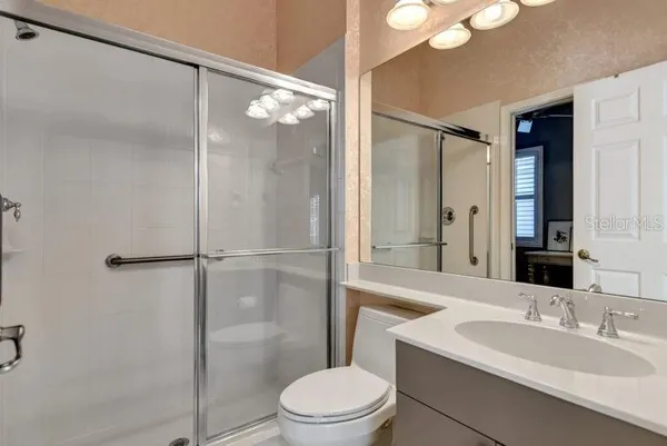 a bathroom with a sink a toilet and shower