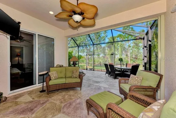 a living room with furniture a floor to ceiling window and a flat screen tv