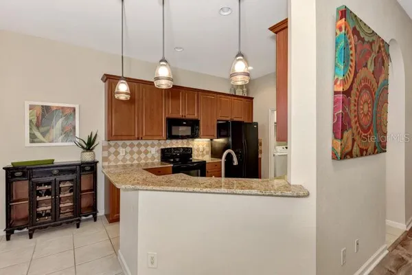 a kitchen with stainless steel appliances granite countertop a sink a stove and a refrigerator