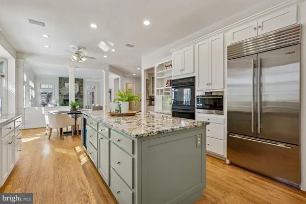 a kitchen with stainless steel appliances granite countertop a stove and a white cabinets