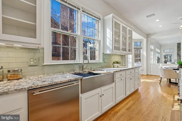 a kitchen with center island a sink dishwasher a stove and a refrigerator with wooden floor