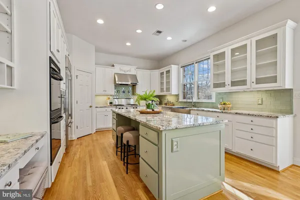 a kitchen with stainless steel appliances white cabinets and a potted plant