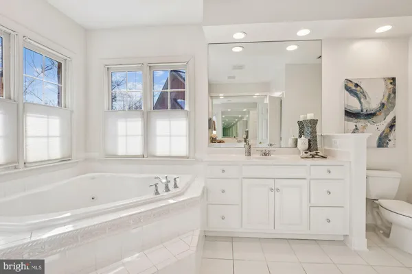a bathroom with a sink vanity granite toilet and shower