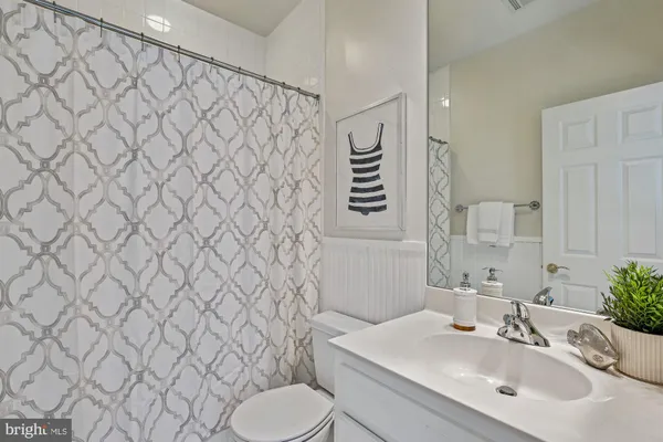 a bathroom with a sink toilet a shower and a mirror