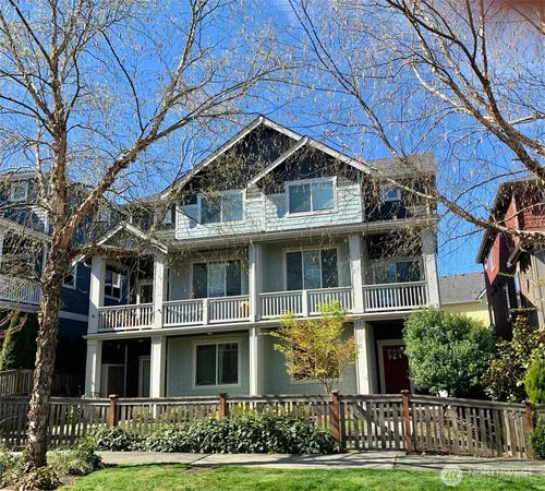 a kitchen with stainless steel appliances granite countertop a stove top oven a sink a dining table and chairs with wooden floor