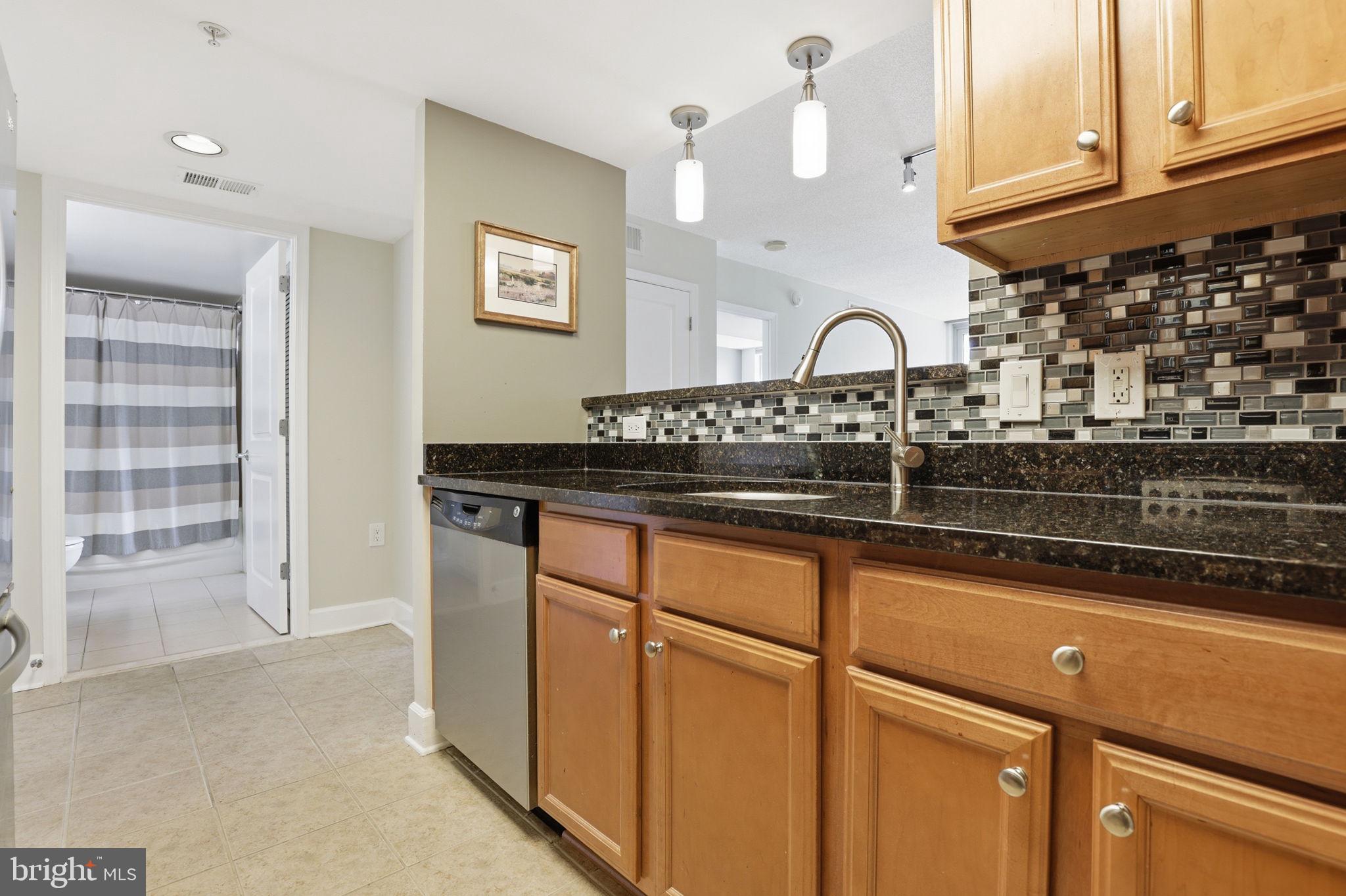11800 Sunset Hills Road, Unit 218 Reston, VA 20190 - Photo 25 of 38 a kitchen with stainless steel appliances granite countertop a stove a sink and a microwave