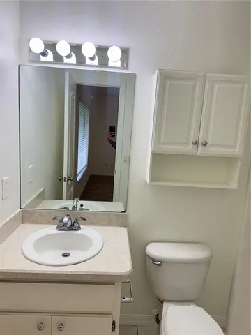 a bathroom with a toilet sink and mirror