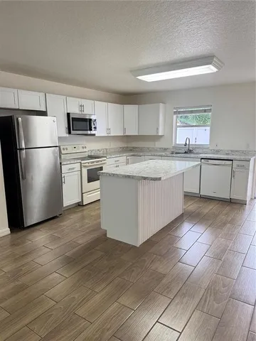 a kitchen with stainless steel appliances granite countertop a refrigerator and a stove top oven