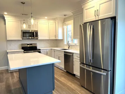 a kitchen with a refrigerator a sink a stove and cabinets