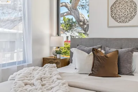 a bedroom with a bed and a painting on the wall