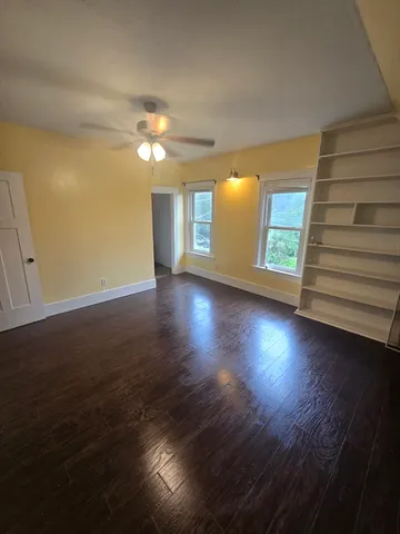 a view of a livingroom with wooden floor and a ceiling fan