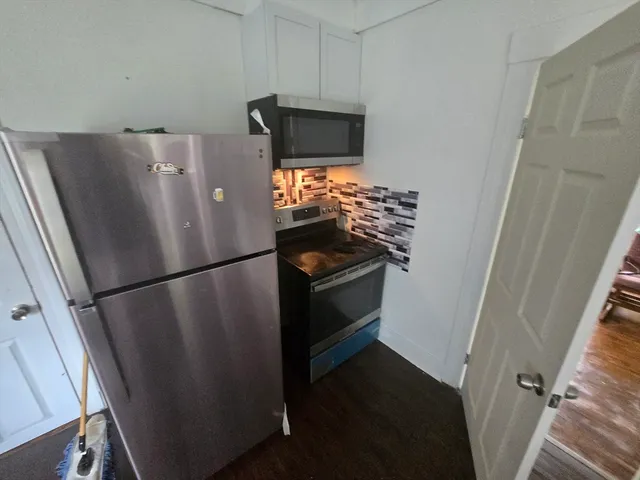 a white refrigerator freezer and a stove sitting inside of a kitchen