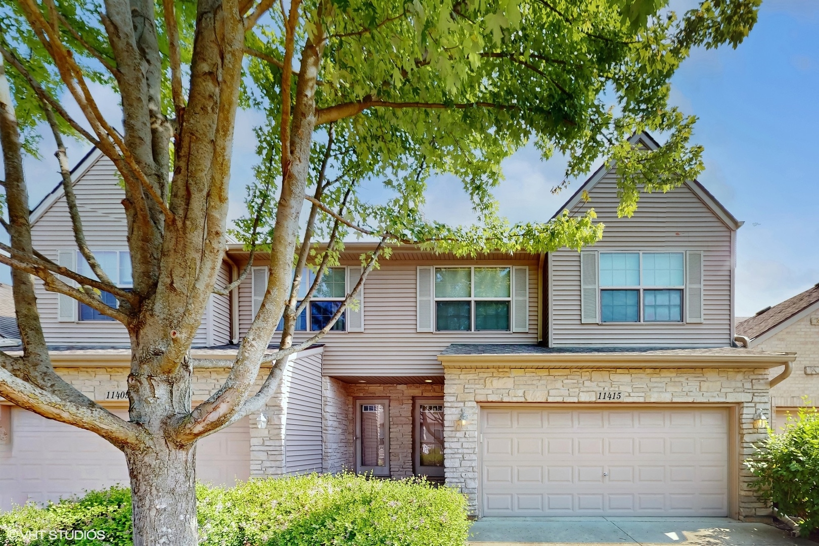 front view of a house with a tree