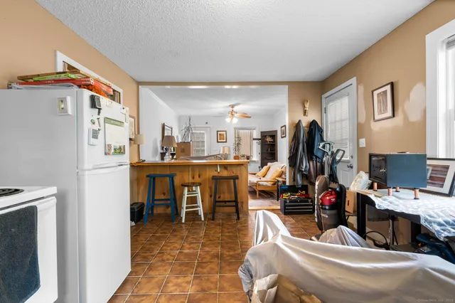 a living room with furniture a flat screen tv and a kitchen view