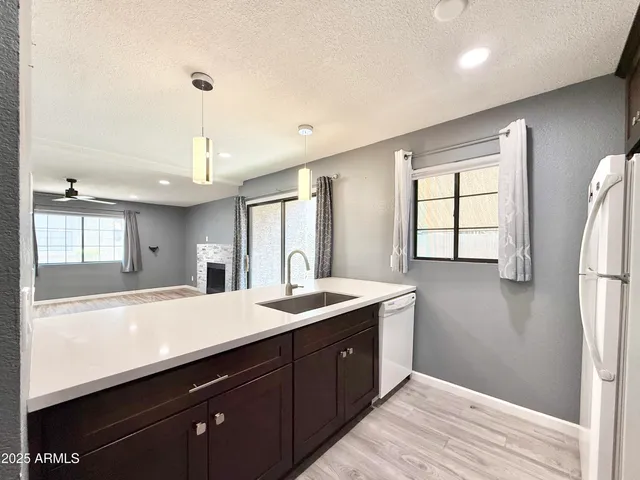 a kitchen with stainless steel appliances granite countertop a sink a window and refrigerator