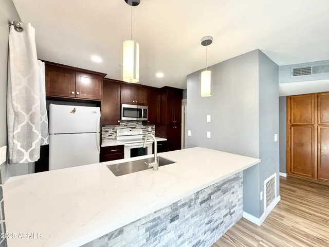 a kitchen with stainless steel appliances a refrigerator sink and stove