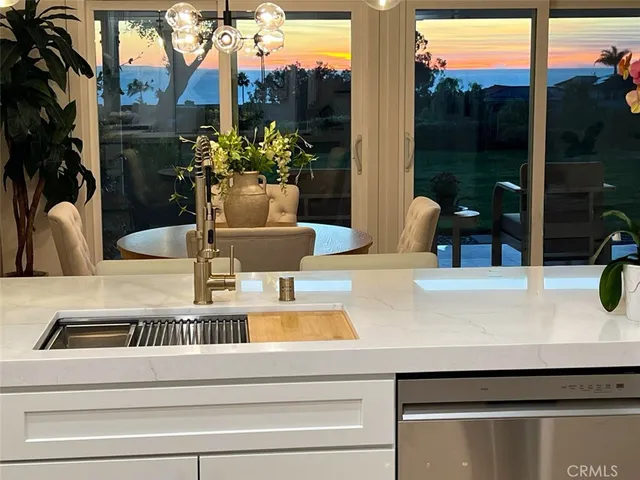 a kitchen with sink a refrigerator and chairs