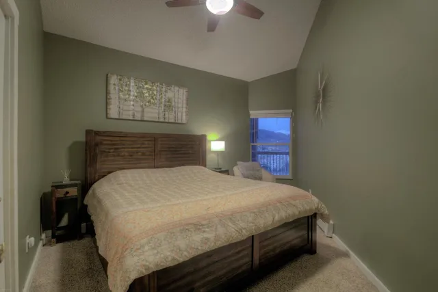 a bedroom with a bed and a lamp on dresser