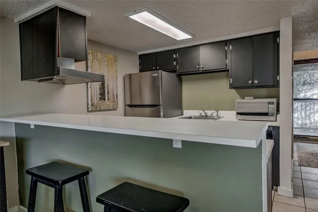 a kitchen with stainless steel appliances a sink and a refrigerator