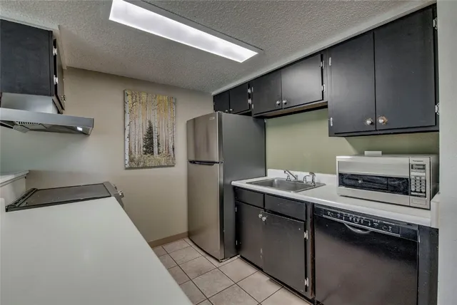 a kitchen with stainless steel appliances a refrigerator a sink and a stove