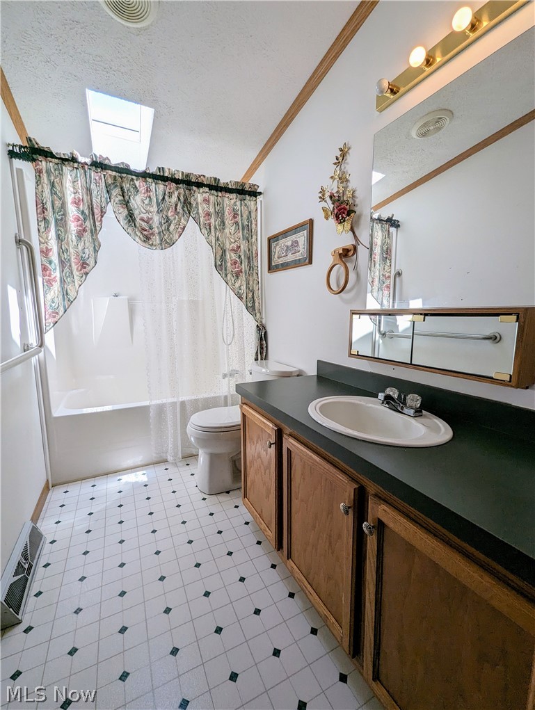 9889 Griffith Road Ravenna, OH 44266 - Photo 44 of 49 Full bathroom with crown molding, toilet, shower / bath combination with curtain, vanity, and a skylight