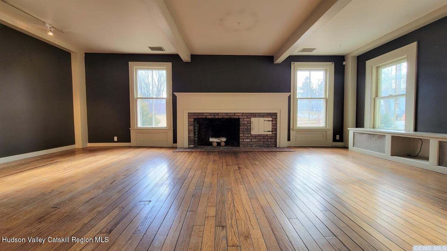 2948 County Rte 9 East Chatham, NY 12060 - Photo 4 of 32 an empty room with wooden floor fireplace and windows