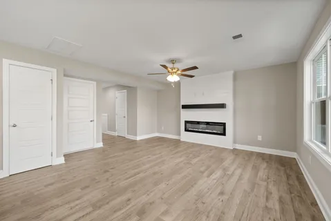 a kitchen with stainless steel appliances granite countertop a stove a refrigerator a sink a dining table and chairs with wooden floor