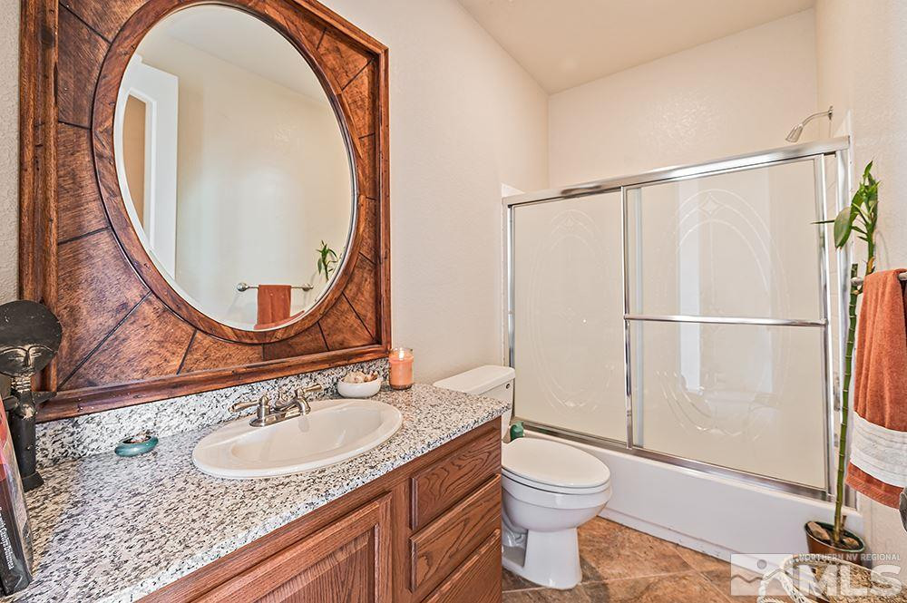 15850 Rocky Vista Road Reno, NV 89521 - Photo 16 of 40 a bathroom with a granite countertop sink toilet mirror vanity and shower