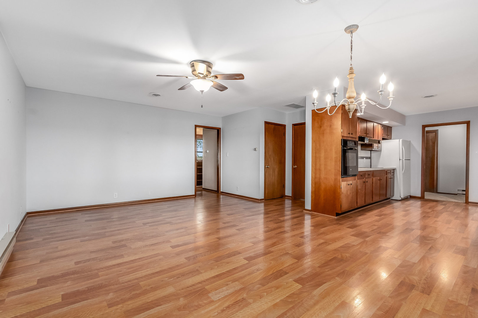 14255 Grove Road Minooka, IL 60447 - Photo 3 of 38 a view of a kitchen with a refrigerator a ceiling fan and wooden floor