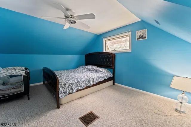 a bedroom with a bed and a lamp on dresser