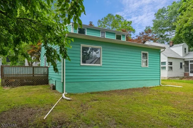 a backyard of a house with plants and wooden fence