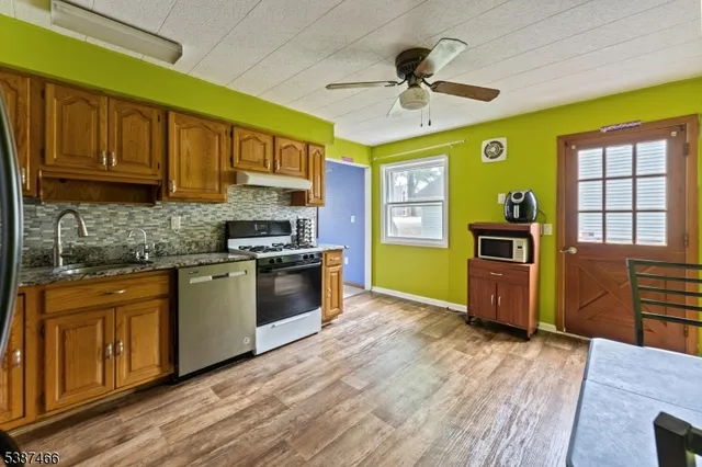 a kitchen with stainless steel appliances granite countertop a stove cabinets and wooden floor