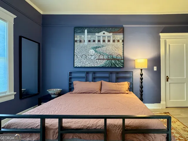 a bedroom with a bed and a painting on the wall