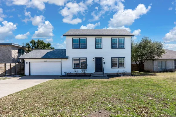 a front view of a house with a yard and garage