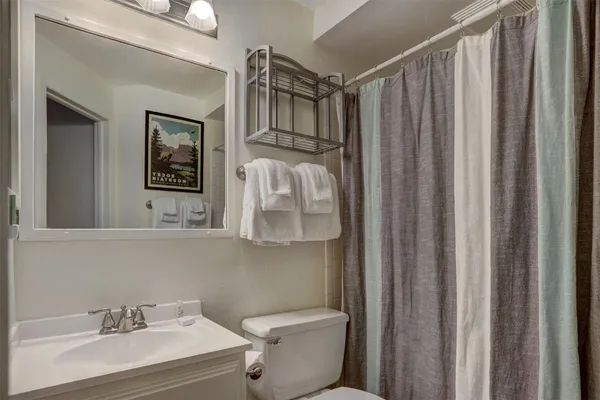 a bathroom with a sink a toilet and shower curtain