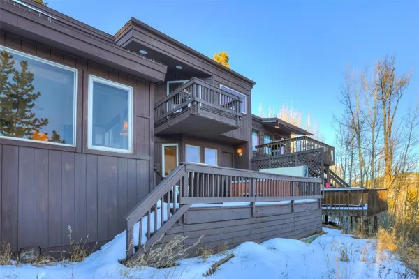 a view of house with wooden deck and outdoor seating