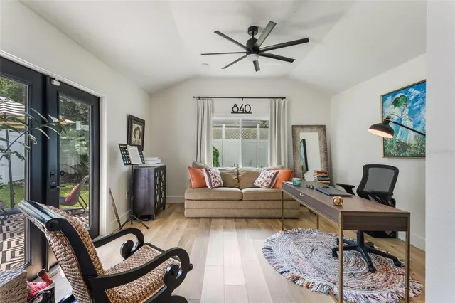 a living room with furniture a ceiling fan and a window