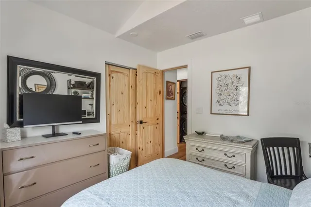 a bedroom with a bed and a flat screen tv in it